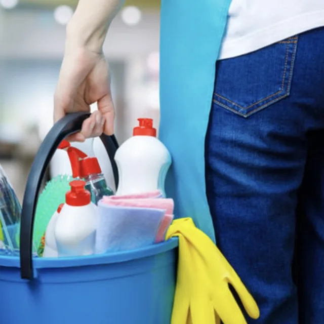Cleaning bucket with spray bottles, gloves, and cloths for residential and commercial cleaning in San Antonio